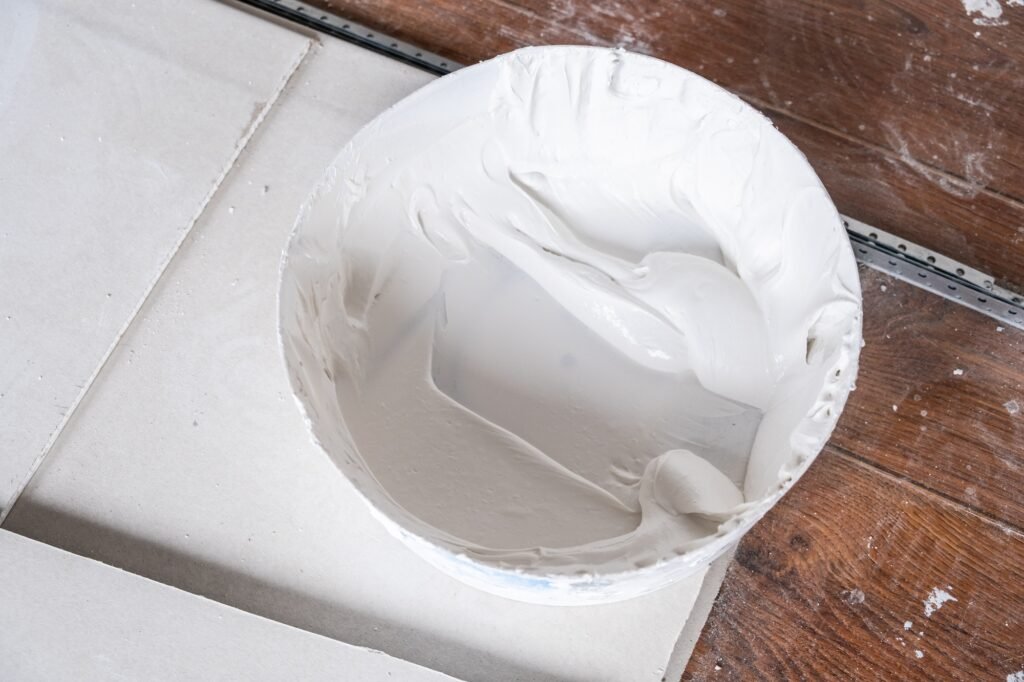 Applying decorative putty. White abstract texture of surface covered with putty