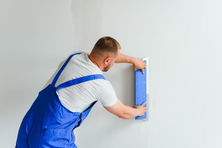 Plasterer smoothes the wall surface with a wall grinder.