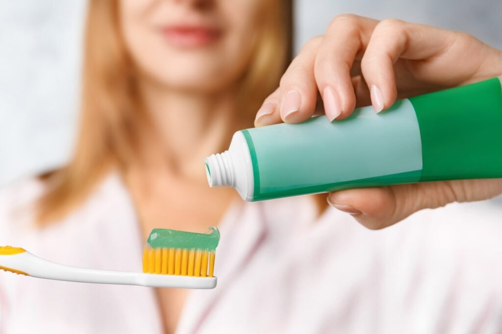 Toothbrush and toothpaste in the hands of a girl close-up.