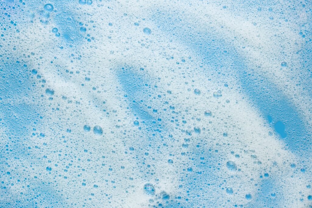 White foam, mousse on a blue background. Concept for foaming products