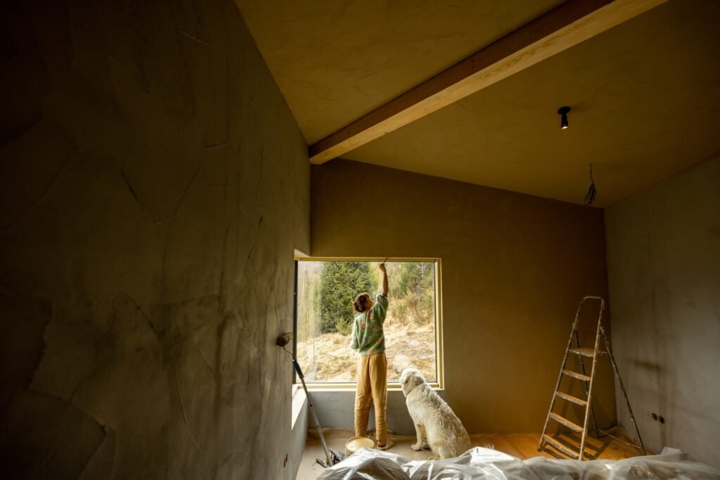 Woman paints walls while making repairment of a new house