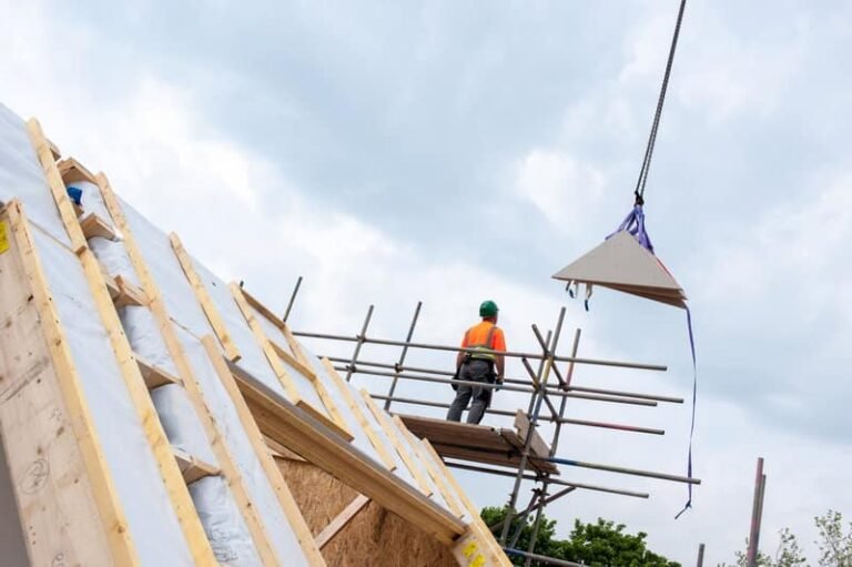 Worker applying EIFS adhesive mortar on EPS insulation board during exterior wall installation | LANDU