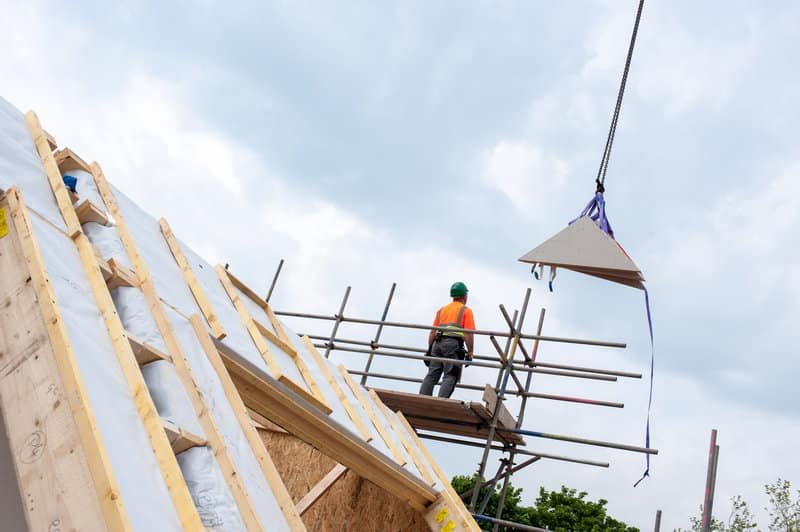 Worker applying EIFS adhesive mortar on EPS insulation board during exterior wall installation | LANDU