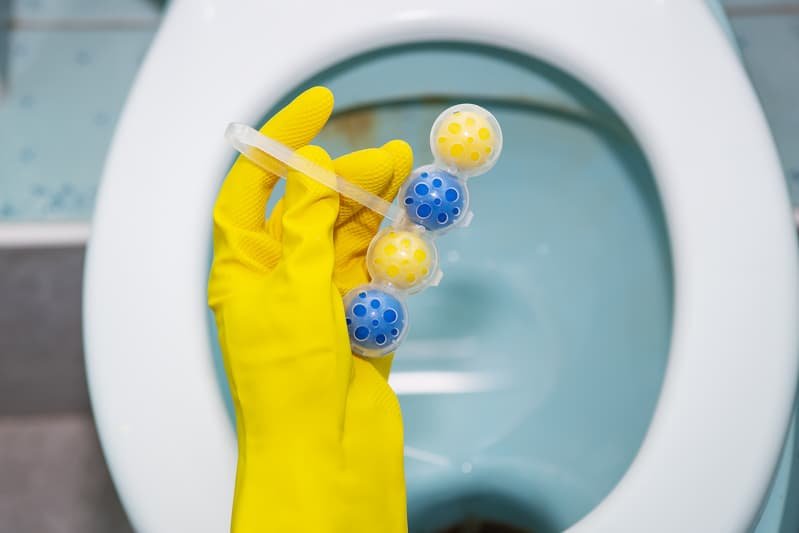 Hand holding toilet cleaning product