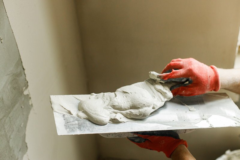 Handyman plastering an interior wall with gypsum plaster